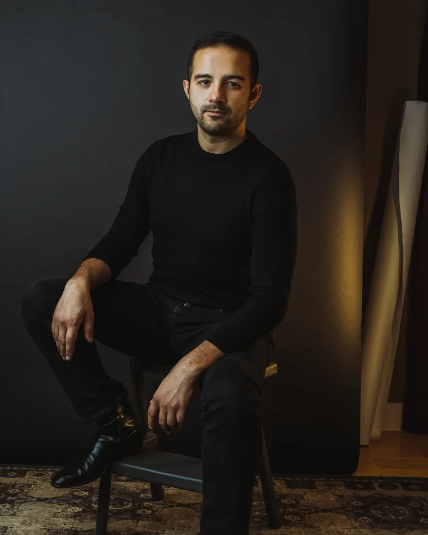 William Kasel seated in front of a dark studio backdrop